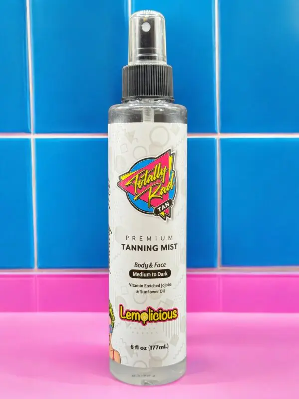 A bottle of tanning mist sitting on top of a pink counter.