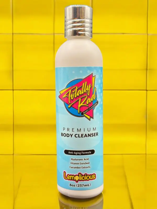 A bottle of body cleanser on a yellow tile wall.