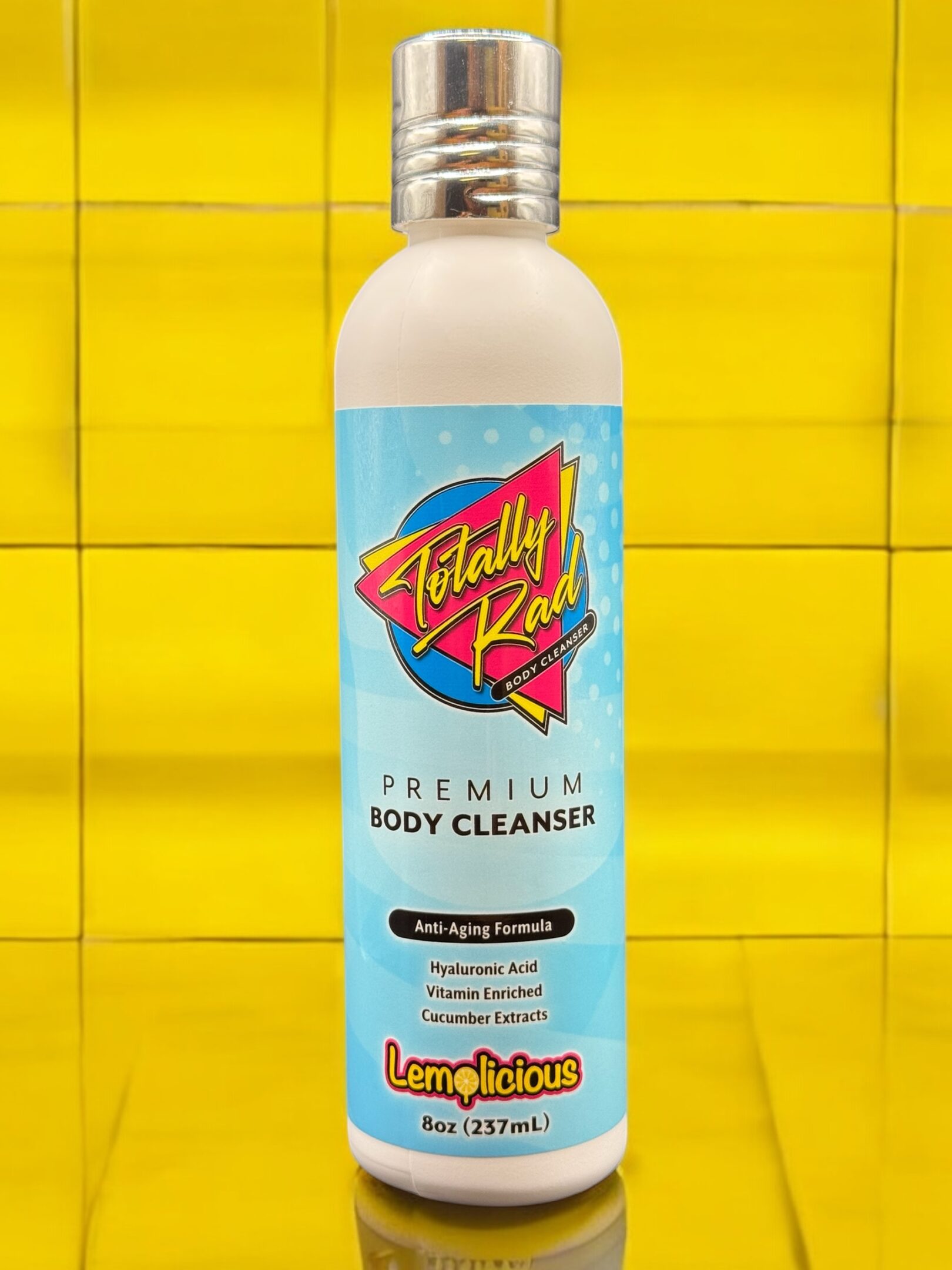 A bottle of body cleanser on a yellow tile wall.