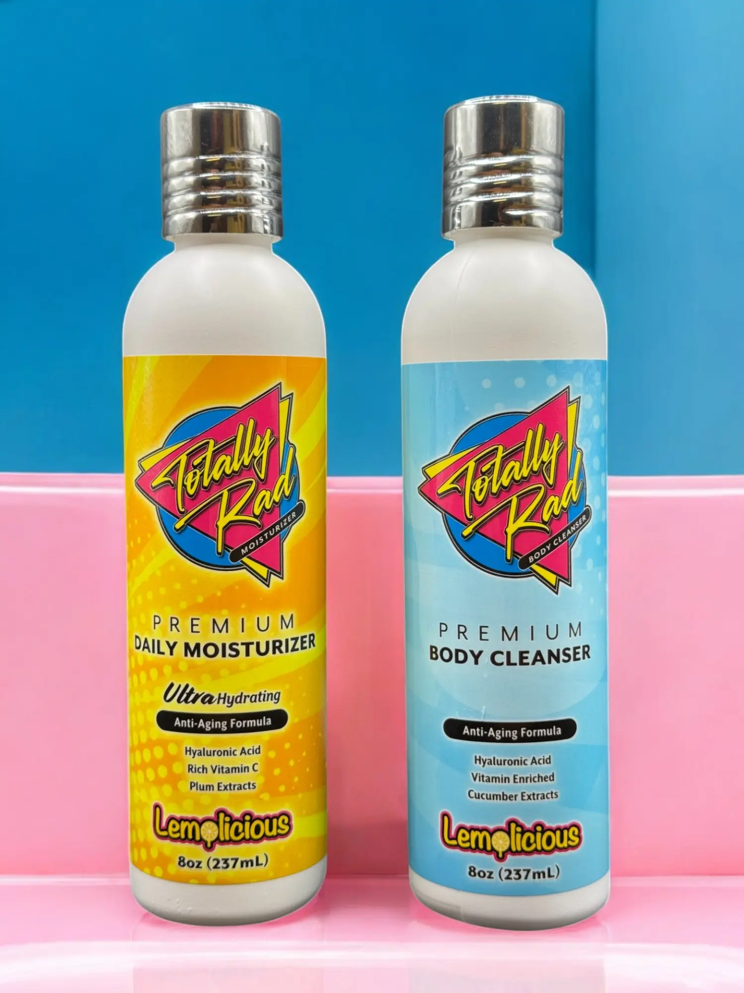 Two bottles of lotion sitting on a pink surface.